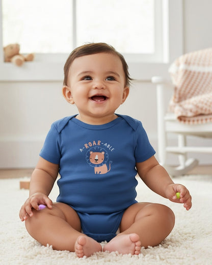 Baby wearing a blue onesie with a lion design and text, sitting on a carpeted floor.