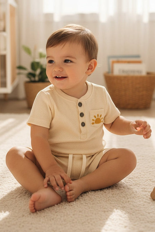 Baby outfit with shirt and shorts on a beige background