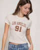 Woman wearing a white t-shirt with 'Los Angeles 91' text on a plain background