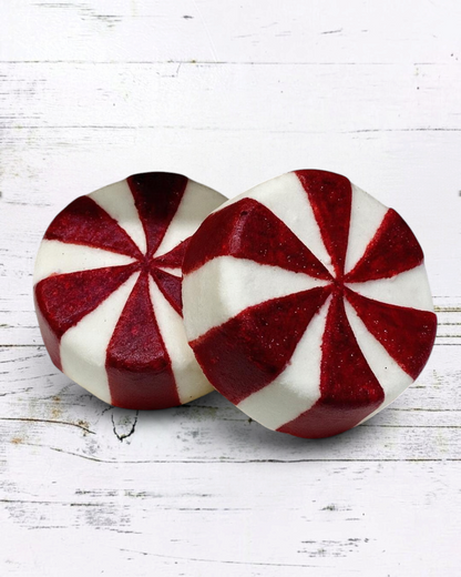 Calla Lily Cosmetics + CL kids peppermint candy bath bombs with red and white swirl design on a white faux fur surface