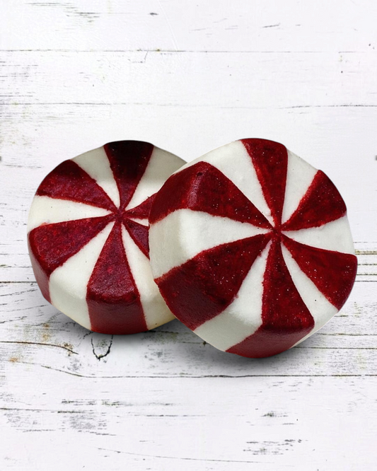 Calla Lily Cosmetics + CL kids peppermint candy bath bombs with red and white swirl design on a white faux fur surface