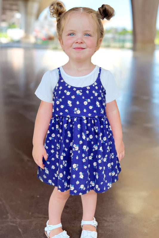 Young girl wearing a blue floral dress with a white background