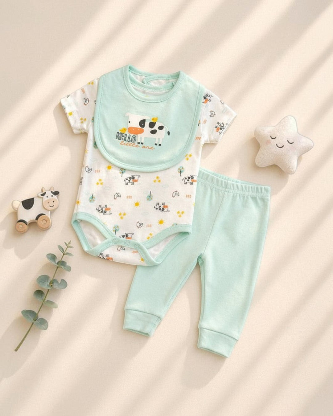 Baby outfit set with bodysuit, bib, and pants on a light background