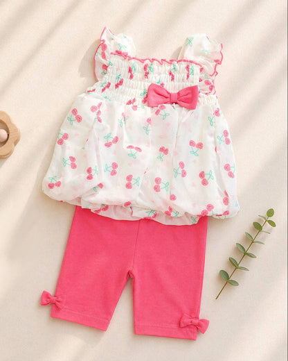 Baby outfit with floral top and pink pants on a beige background