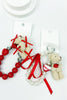 Two teddy bear keychains with red and pearl ribbons on a white background