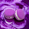 Two purple unicorn yawns bath cookies against a purple watery background