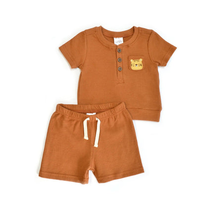 Children's orange outfit with shirt and shorts on a white background