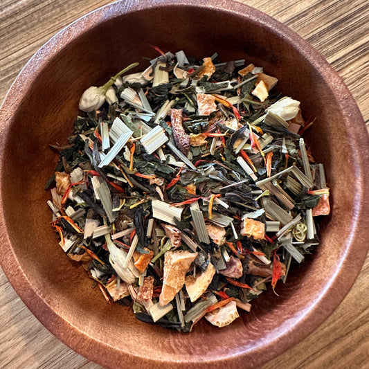 Wooden bowl filled with a mix of dried herbs and vegetables on a wooden surface