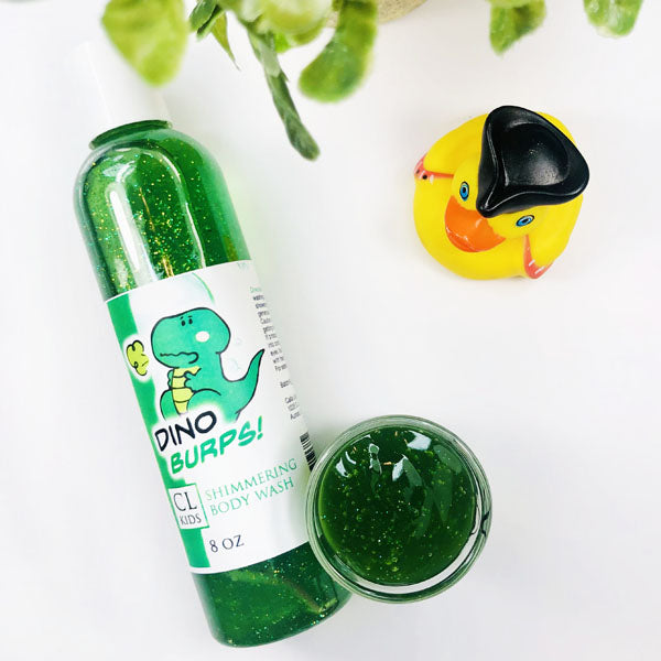 A transparent bottle and cup of our green dino burps body wash against a white background