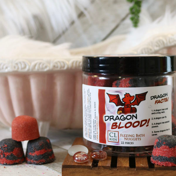 A container of gumdrop shaped red and black "dragons blood" bath bombs with a tiny 3 bath bomb pyramid to its side