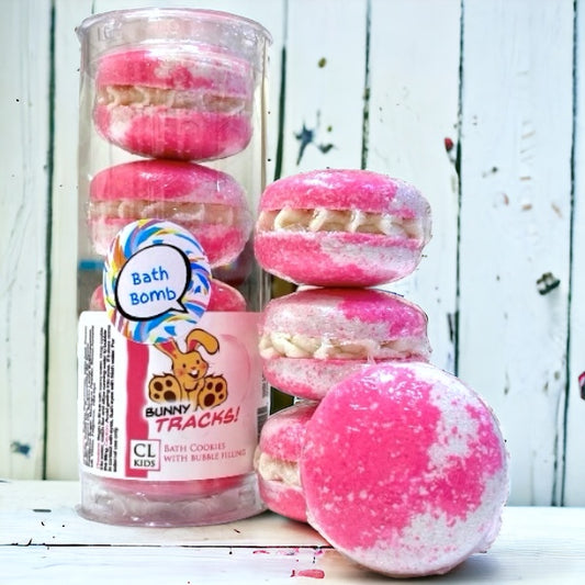 A stack and tube of pink and white bunny tracks bath cookies against a wood background