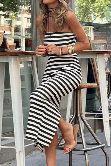 Woman in a black and white striped dress sitting at an outdoor cafe.
