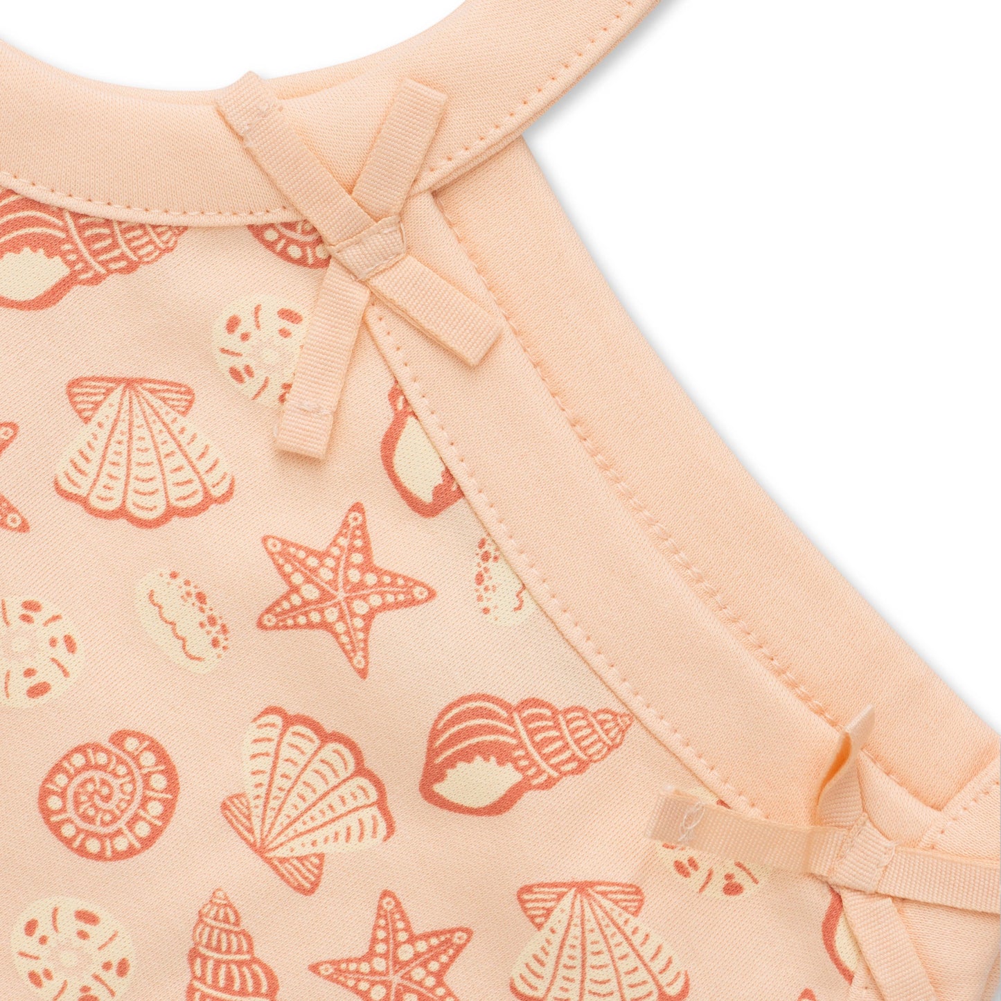 Baby outfit with shell pattern on a peach background