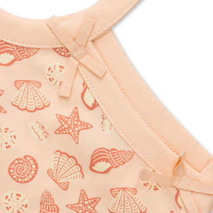 Baby outfit with shell pattern on a peach background