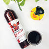 A transparent bottle and cup of our dark red dragons blood body wash against a white background