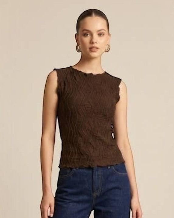 Woman wearing a brown sleeveless top and blue jeans on a beige background