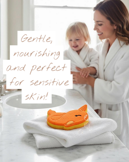 Calla Lily Cosmetics + CL kids orange narwhal bath bomb on a white towel with a mother and child in the background