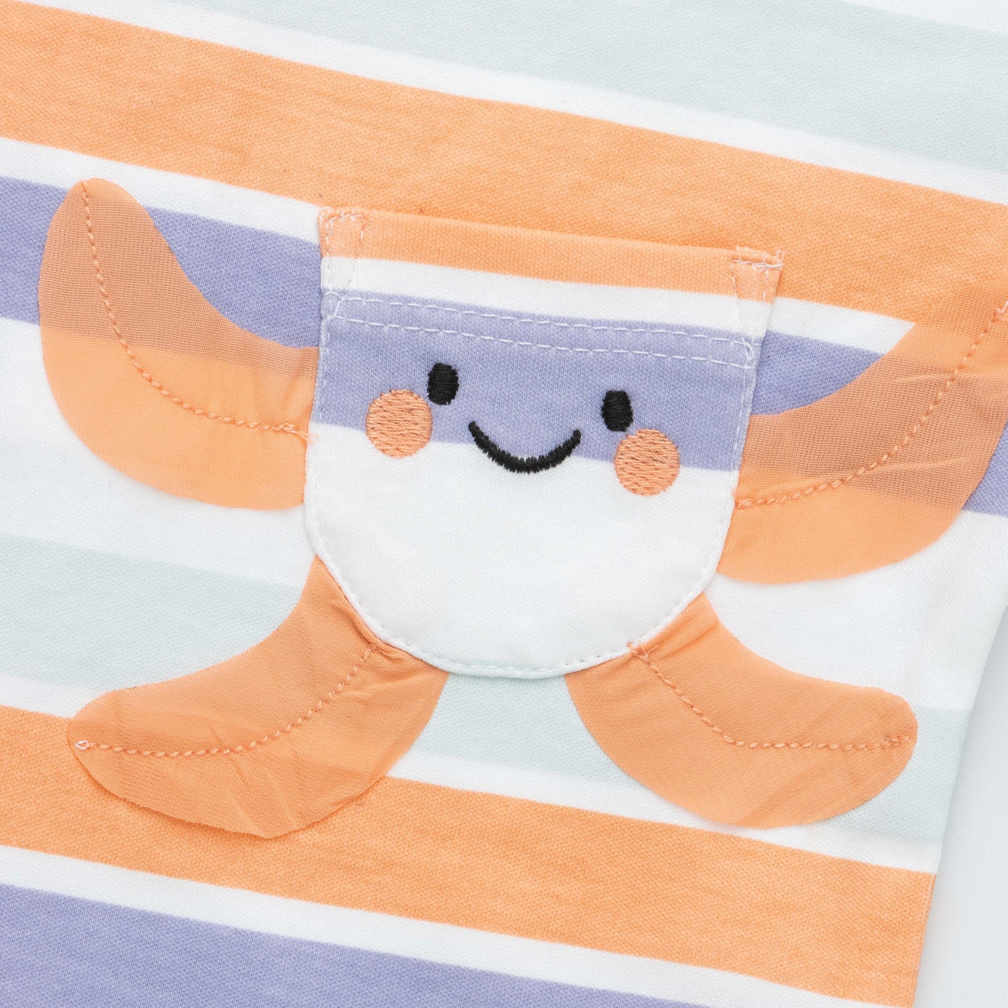 Close-up of a fabric character with a smiley face on a striped background