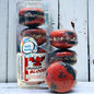 A stack and tube of red and black dragons blood bath cookies against a wood background