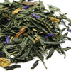 Pile of green tea leaves with some dried flowers on a white background