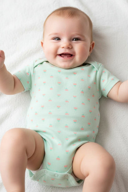 Mint green baby onesie with small patterns on a white background