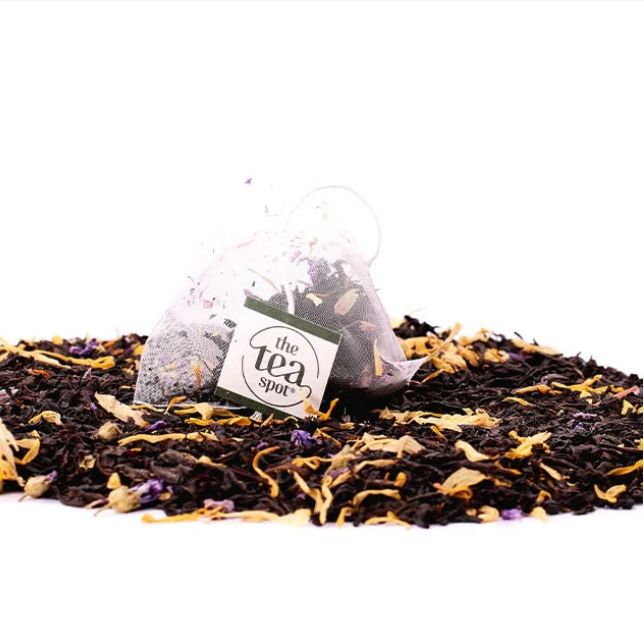 Tea bags with floral elements on a white background, featuring 'the tea spot' brand.