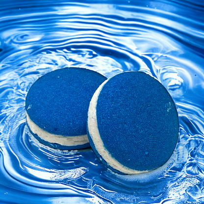 Two blue sheep bath cookies against a blue water background