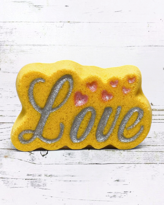 Calla Lily Cosmetics + CL kids yellow Love bath bomb with silver glitter lettering and pink heart accents