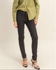 A woman modeling a long-sleeve olive green blouse with a unique gathered front and black skinny jeans, paired with black strappy high heels, against a plain beige studio background.