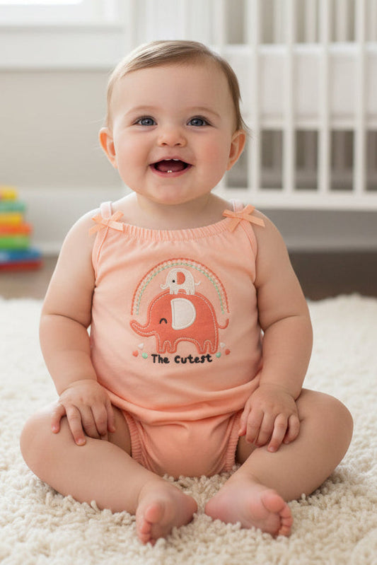 Peach-colored baby romper with elephant design on a white background
