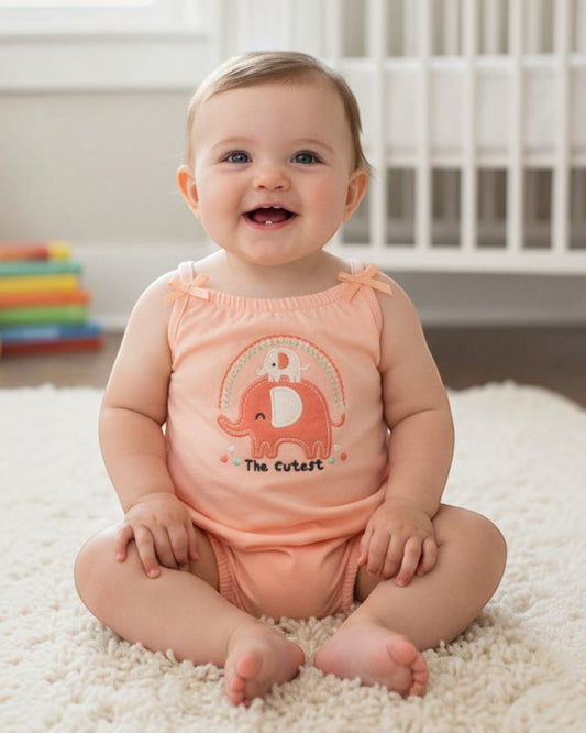 Peach-colored baby romper with elephant design on a white background