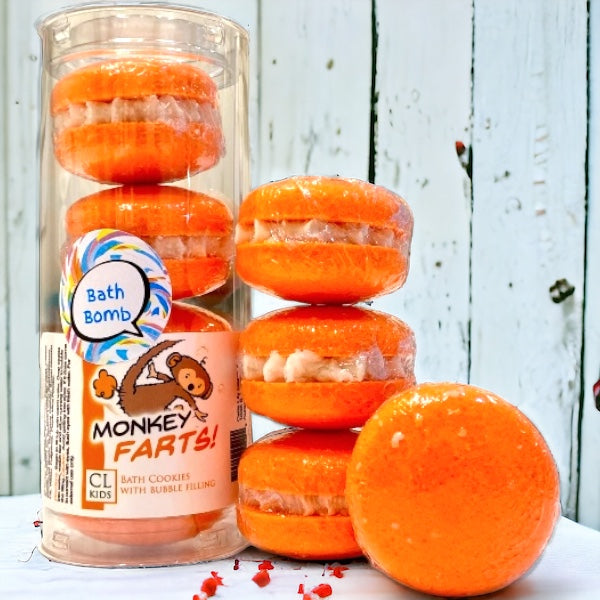 A stack and tube of orange milo monkey bath cookies against a wood background