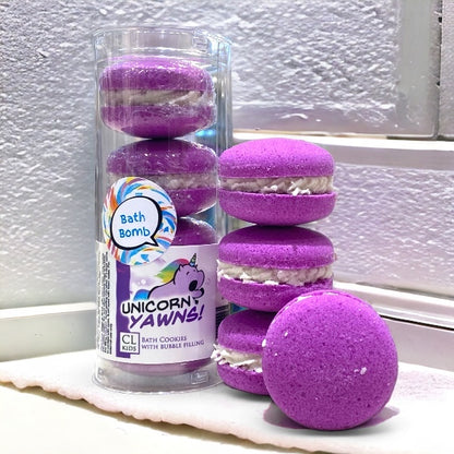 A stack and tube of purple unicorn yawns bath cookies against a white wall