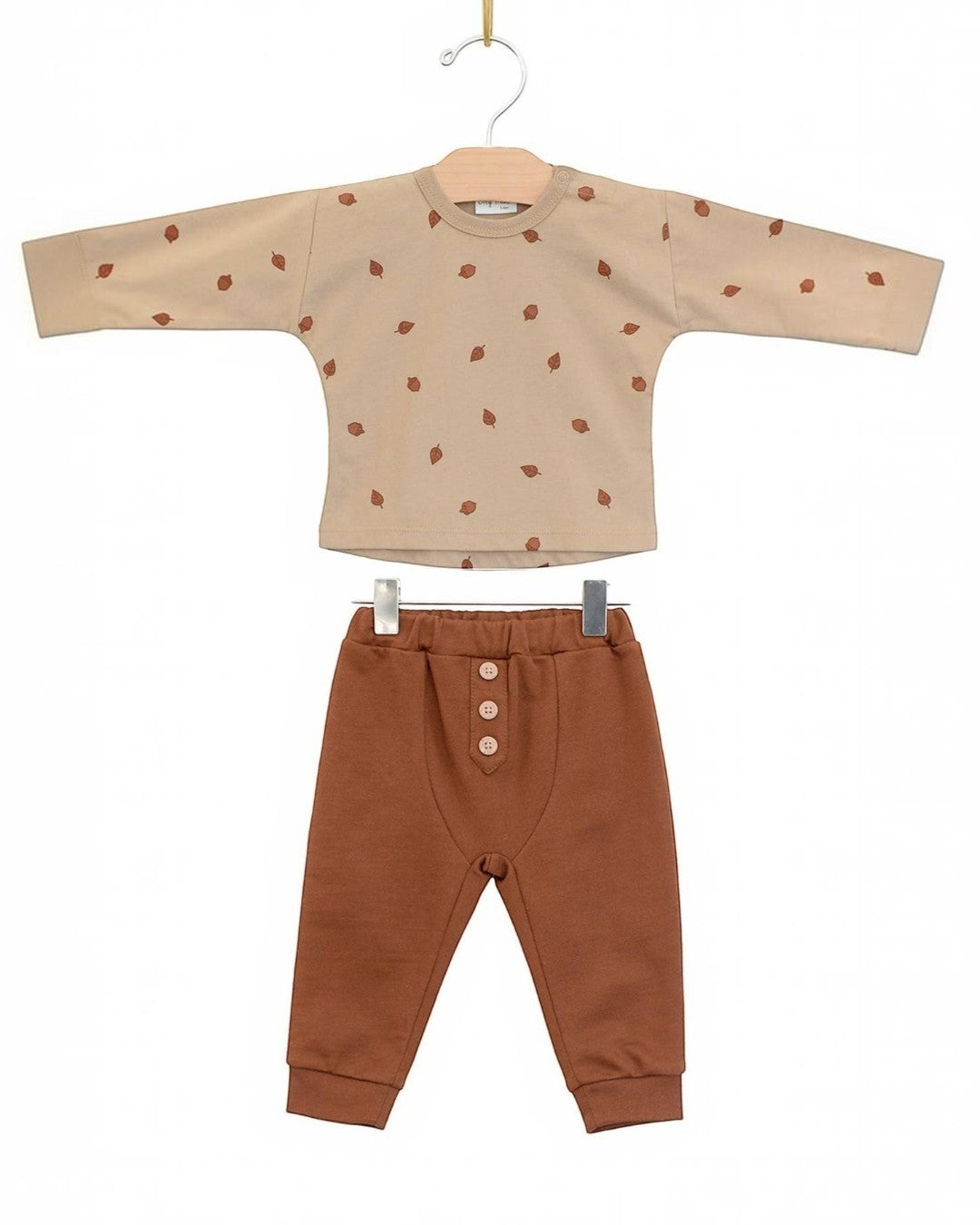 Children's outfit with beige top and brown pants on a white background