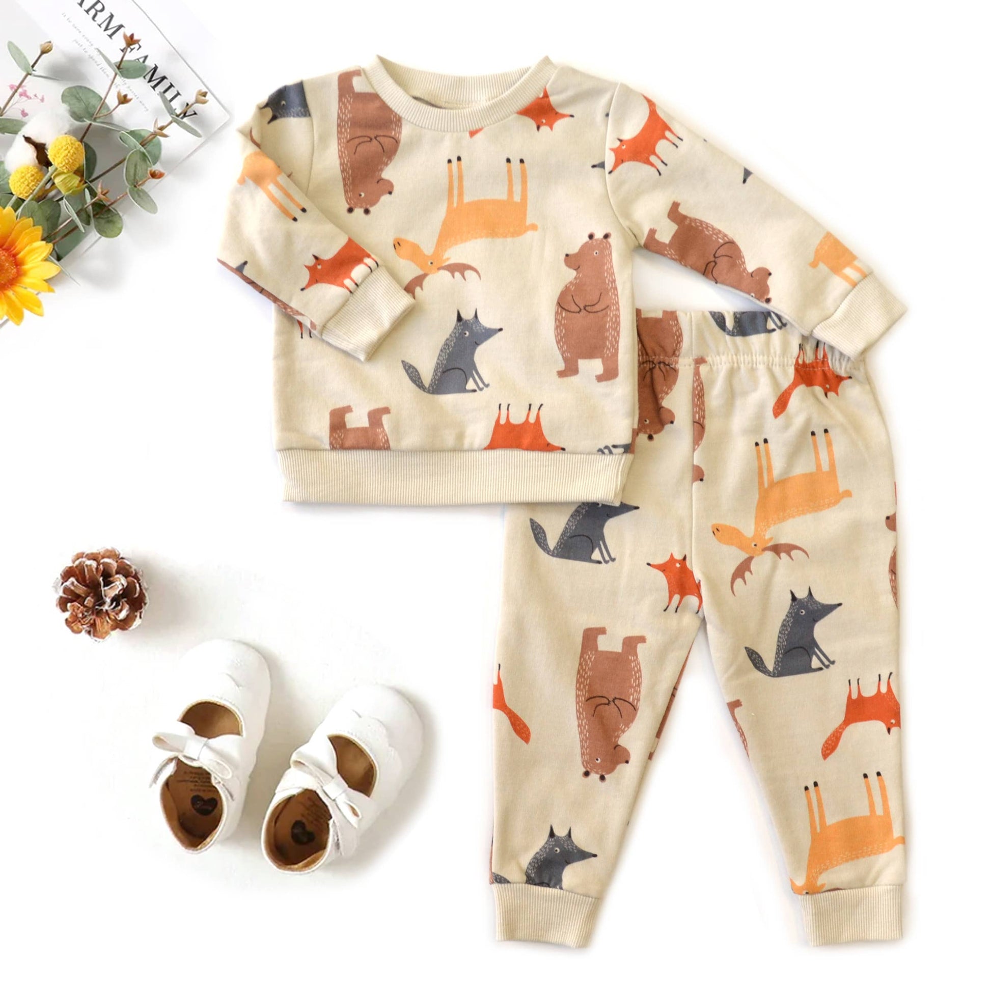 Children's pajama set with animal pattern and shoes on a white background