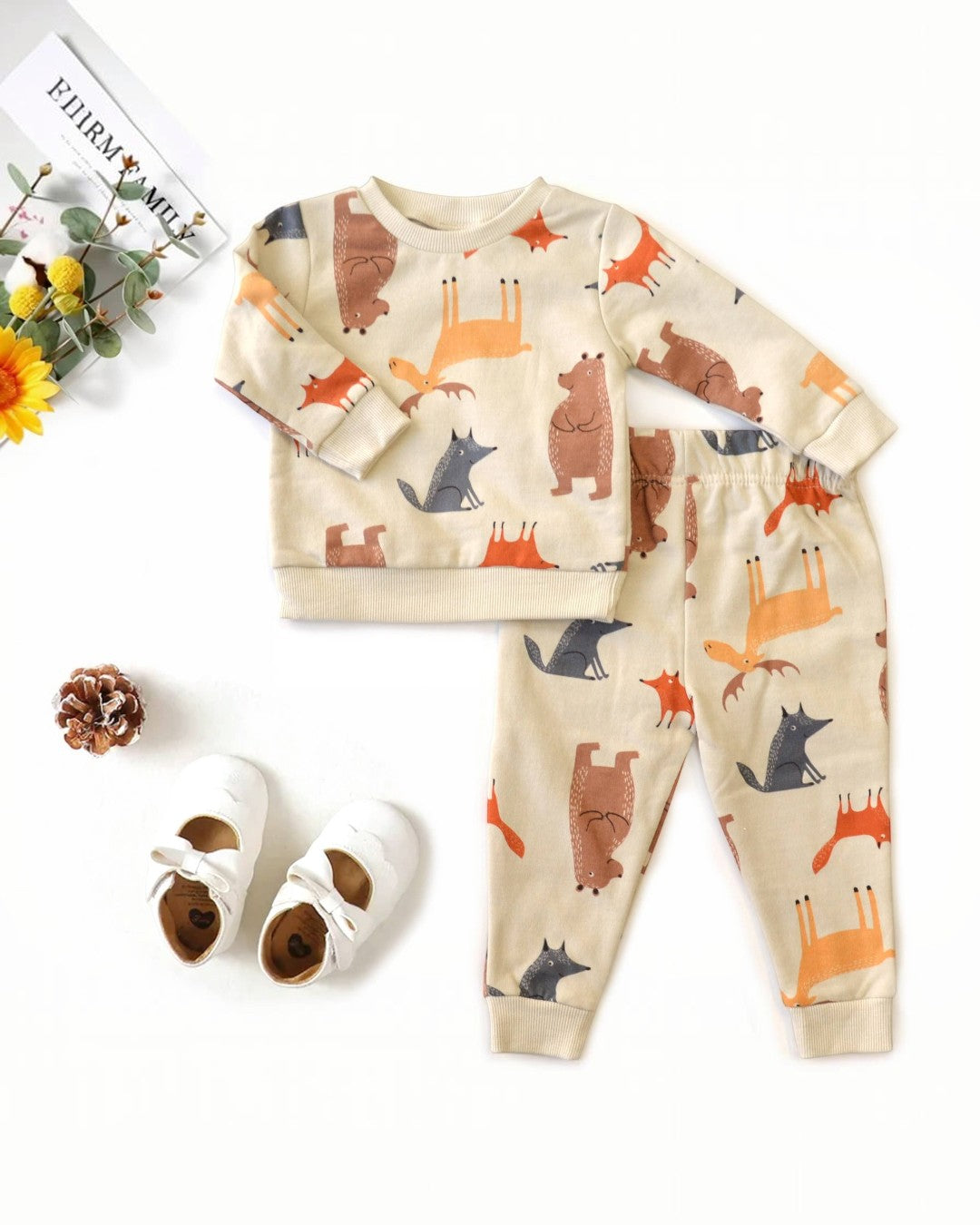 Children's pajama set with animal pattern and shoes on a white background