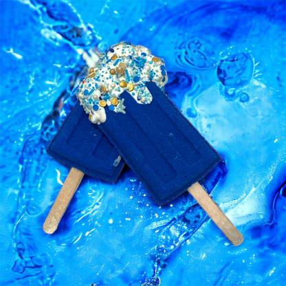 Two blue popsicle bath bombs against a blue watery background