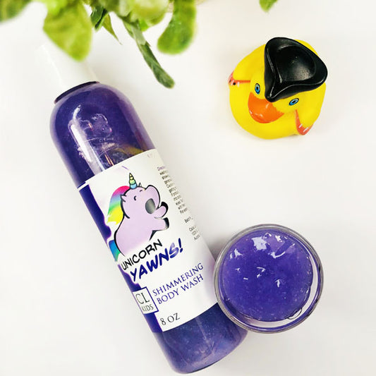 A transparent bottle and cup of our purple unicorn yawns body wash against a white background