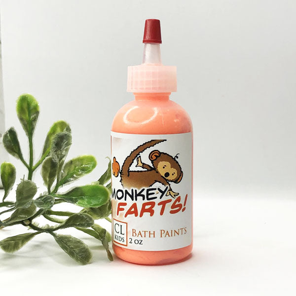 A bottle of our orange monkey farts bath paints against a white background