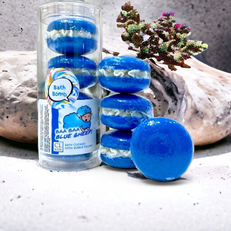 A stack and tube of blue sheep bath cookies in front of a stone