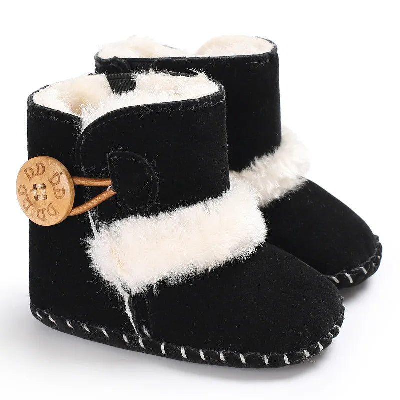 Black baby boots with white fur trim and wooden button on a white background