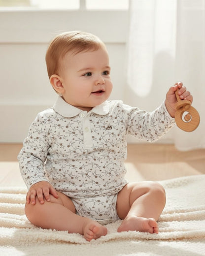 Baby sitting on a rug holding a wooden toy in a bright room.