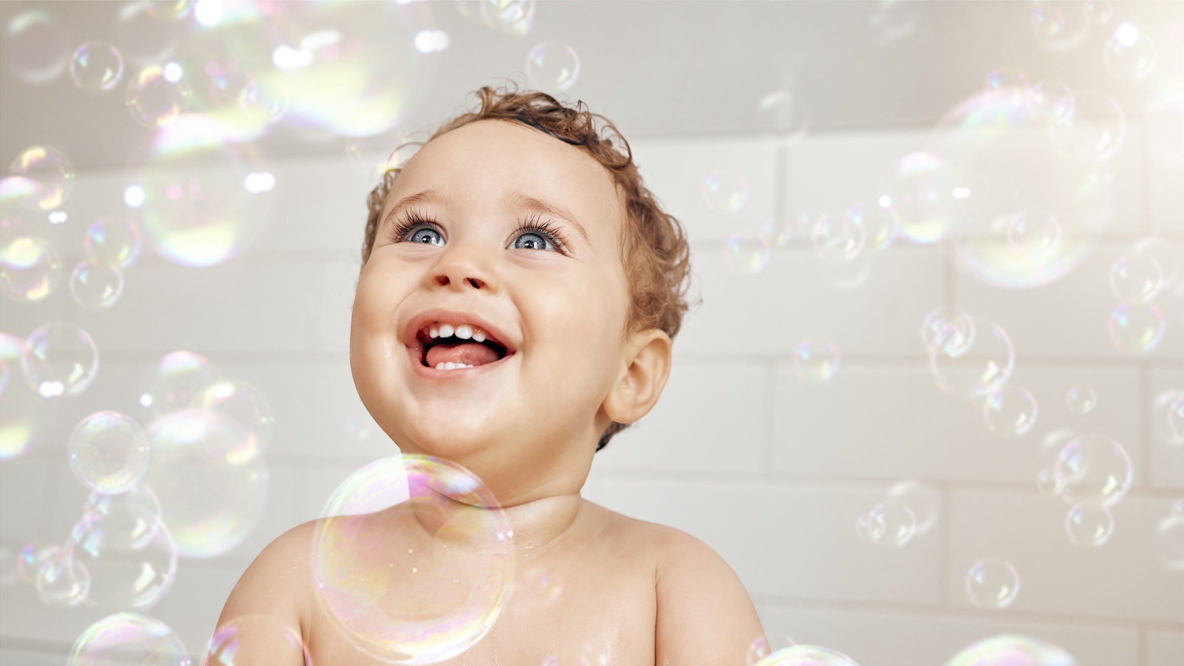 Baby playing with bubbles in a bathtub