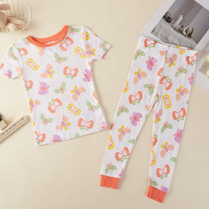 Children's pajama set with butterfly pattern on a beige surface