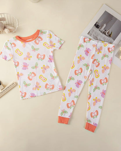 Children's pajama set with butterfly pattern on a beige surface