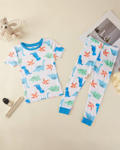 Children's pajama set with dinosaur pattern on a beige surface