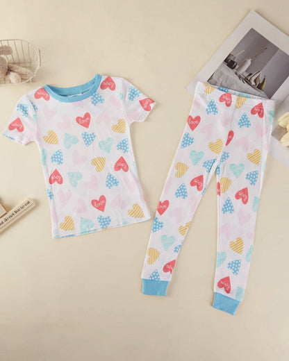 Children's pajama set with heart patterns on a beige surface