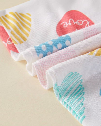 Set of colorful baby bibs with different patterns on a beige background