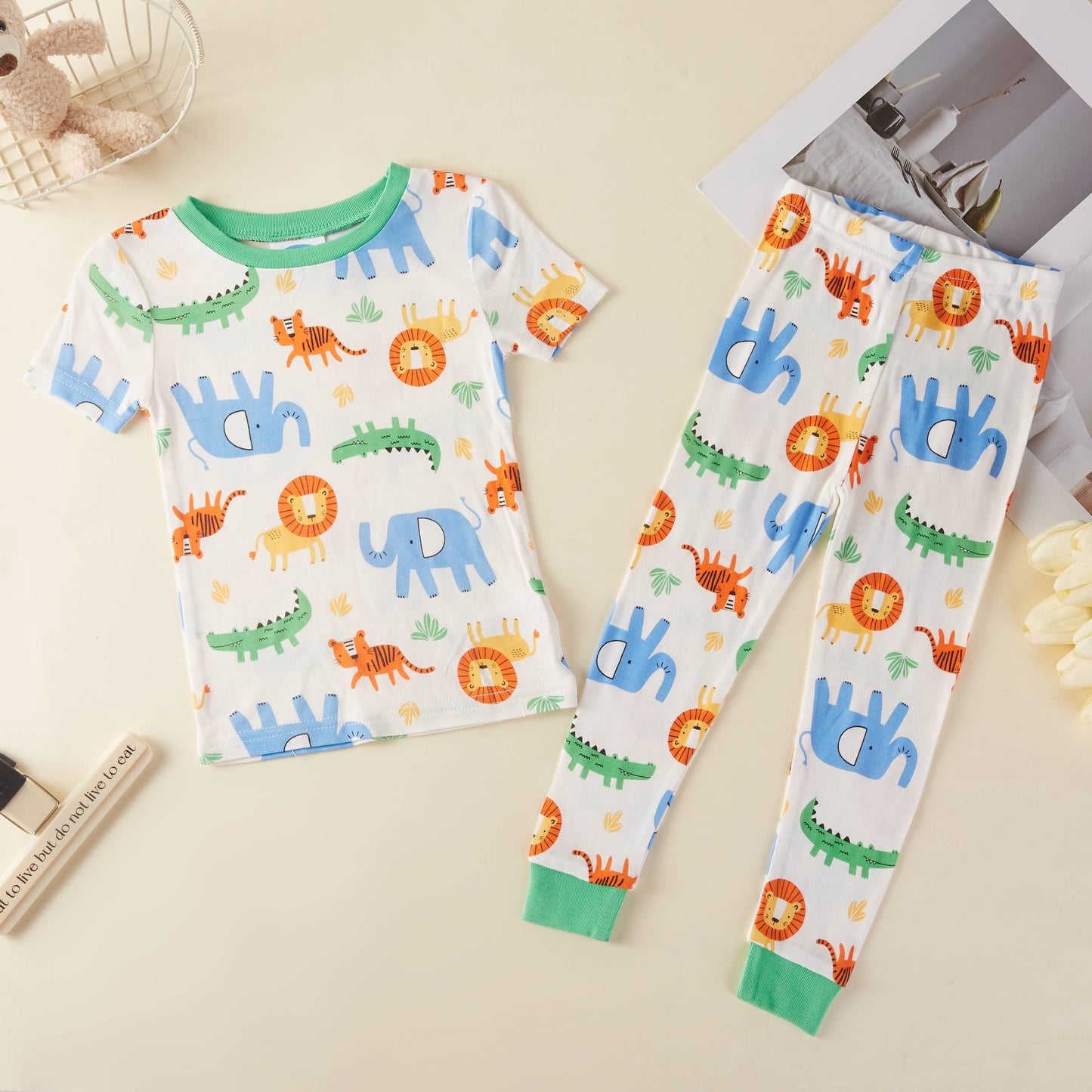 Children's pajama set with animal patterns on a beige surface