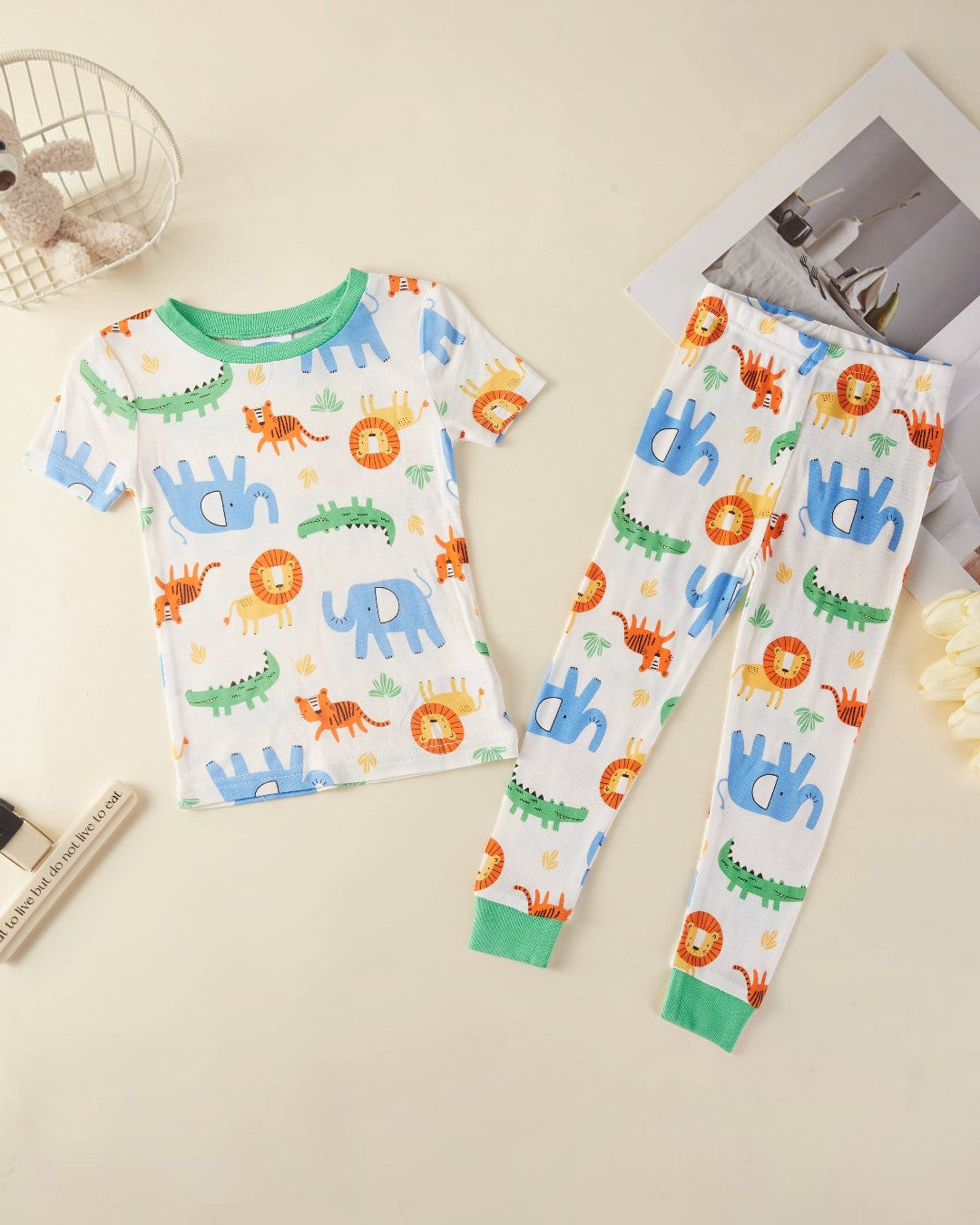 Children's pajama set with animal patterns on a beige surface